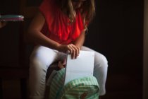 Ausgeschnittene Ansicht eines Mädchens, das seinen Rucksack mit Schreibwaren packt — Stockfoto