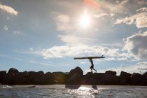 Далеких зору людини, несучи для серфінгу над порід — стокове фото