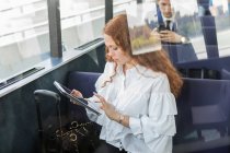 Молода бізнес-леді, використовуючи цифровий планшетний сенсорний екран на пасажирському поромі — стокове фото