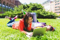 Mulher no parque da cidade usando laptop na grama, Milão, Itália — Fotografia de Stock