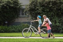 Menino na rua aprendendo a andar de bicicleta — Fotografia de Stock