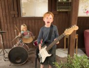 Children playing guitar and drums in band — Stock Photo