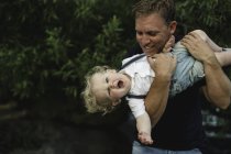 Mature man holding up toddler son — Stock Photo