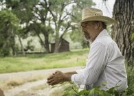 Uomo maturo con cappello da cowboy appoggiato alla recinzione del ranch, Bridger, Montana, USA — Foto stock