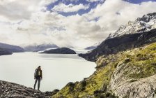Vista panorámica del senderista masculino sobre el Lago Grey y el Glaciar, Parque Nacional Torres del Paine, Chile - foto de stock