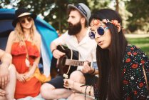 Young boho adults playing acoustic guitar at festival — Stock Photo