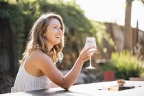 Giovane donna all'aperto in possesso di bicchiere di vino — Foto stock