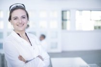 Portrait de travailleuse de laboratoire, bras croisés, sourire — Photo de stock