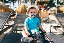 Porträt eines kleinen Jungen auf einer Sonnenliege — Stockfoto