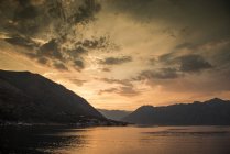 Silhueta de montanhas por água ao pôr do sol, Kotor, Montenegro, Europa — Fotografia de Stock