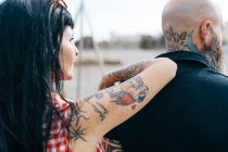 Mature tattooed hipster woman leaning on boyfriends shoulder — Stock Photo