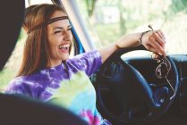 Молода бохо-жінка сміється на передньому сидінні розважального фургона — стокове фото