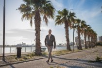 Hombre paseando por el paseo marítimo, Cagliari, Cerdeña, Italia, Europa - foto de stock