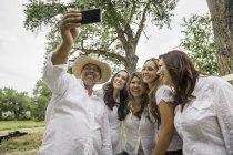 Mature couple taking smartphone selfie with young women on ranch, Bridger, Montana, USA — Stock Photo