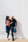 Mature couple hipster appuyé contre le mur blanc — Photo de stock