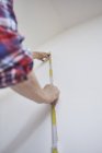 Cropped image of man measuring white wall — Stock Photo