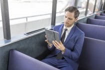 Giovane uomo d'affari sul traghetto passeggeri guardando tablet digitale — Foto stock