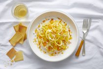 Pasta di zucca gialla spiralata con pomodoro ciliegia giallo, feta, pepe d'arancia e coulis di pepe arancione — Foto stock
