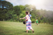 Девочка играет в бейсбол на поле — стоковое фото