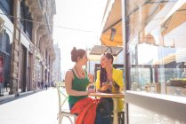 Mujeres en la ciudad descanso en la cafetería al aire libre, Milán, Italia - foto de stock