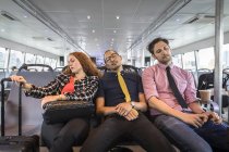 Empresária e homens dormindo em balsa de passageiros — Fotografia de Stock