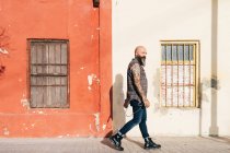 Mature male hipster walking along sidewalk — Stock Photo