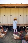 Giovane ragazza in fattoria, raccogliendo uova da pollaio — Foto stock