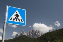 Segno di attraversamento pedonale sopra i monti Odle e cielo blu, Valle di Funes, Dolomiti, Italia — Foto stock