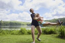 Девушки играют на траве у озера — стоковое фото