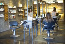 Female hairstylist working with customer in salon — Stock Photo