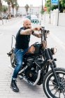 Portrait of mature male hipster astride motorcycle, Valencia, Spain — Stock Photo