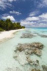 Playa de arena blanca, palmeras y mar azul, Fakarava, Archipiélago de Tuamotu, Polinesia Francesa - foto de stock