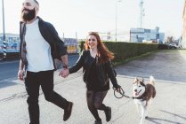 Jovem casal andando com cão fora — Fotografia de Stock