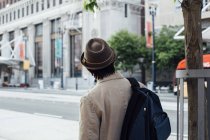Молодой человек выходит на улицу с рюкзаком — стоковое фото