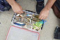 Fisher mãos selecionando gancho de pesca na praia — Fotografia de Stock