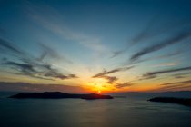 Puesta de sol sobre el mar en el horizonte, Oia, Santorini, Kikladhes, Grecia - foto de stock