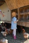 Junges Mädchen auf Bauernhof sammelt Eier aus Hühnerstall — Stockfoto