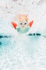 Young boy swimming under water in swimming pool, underwater view — Stock Photo