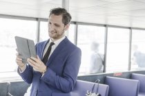 Young businessman looking at digital tablet on passenger ferry — Stock Photo