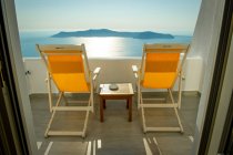 Espreguiçadeiras na varanda com vista para o mar, Oia, Santorini, Kikladhes, Grécia — Fotografia de Stock