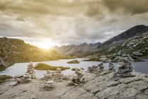 Steinhaufen am See bei Sonnenuntergang, san bernardino, ticino, schweiz, europa — Stockfoto