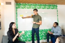 Jeune entrepreneur adult pointant sur tableau blanc dans la salle de réunion créative — Photo de stock