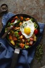 Хеш сніданку зі смаженим яйцем у чавунній сковороді — стокове фото