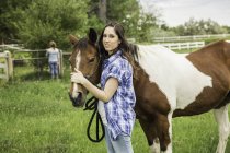 Portrait of young woman and horse in ranch field, Bridger, Montana, USA — Stock Photo
