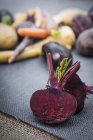 Gemüseauswahl, Rote Bete im Vordergrund halbiert, Nahaufnahme — Stockfoto