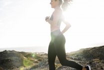 Vista laterale della giovane donna che corre vicino alla costa, Las Palmas, Isole Canarie, Spagna — Foto stock