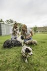 Две молодые женщины играют с щенками на ранчо, Бриджер, Монтана, США — стоковое фото