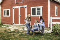 Trois jeunes femmes riant devant une ferme de ranch, Bridger, Montana, USA — Photo de stock