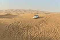 Geländewagen fährt Wüstendünen hinunter, Dubai, vereinigte arabische Emirate — Stockfoto