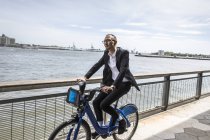Side view of businessman cycling on waterfront — Stock Photo